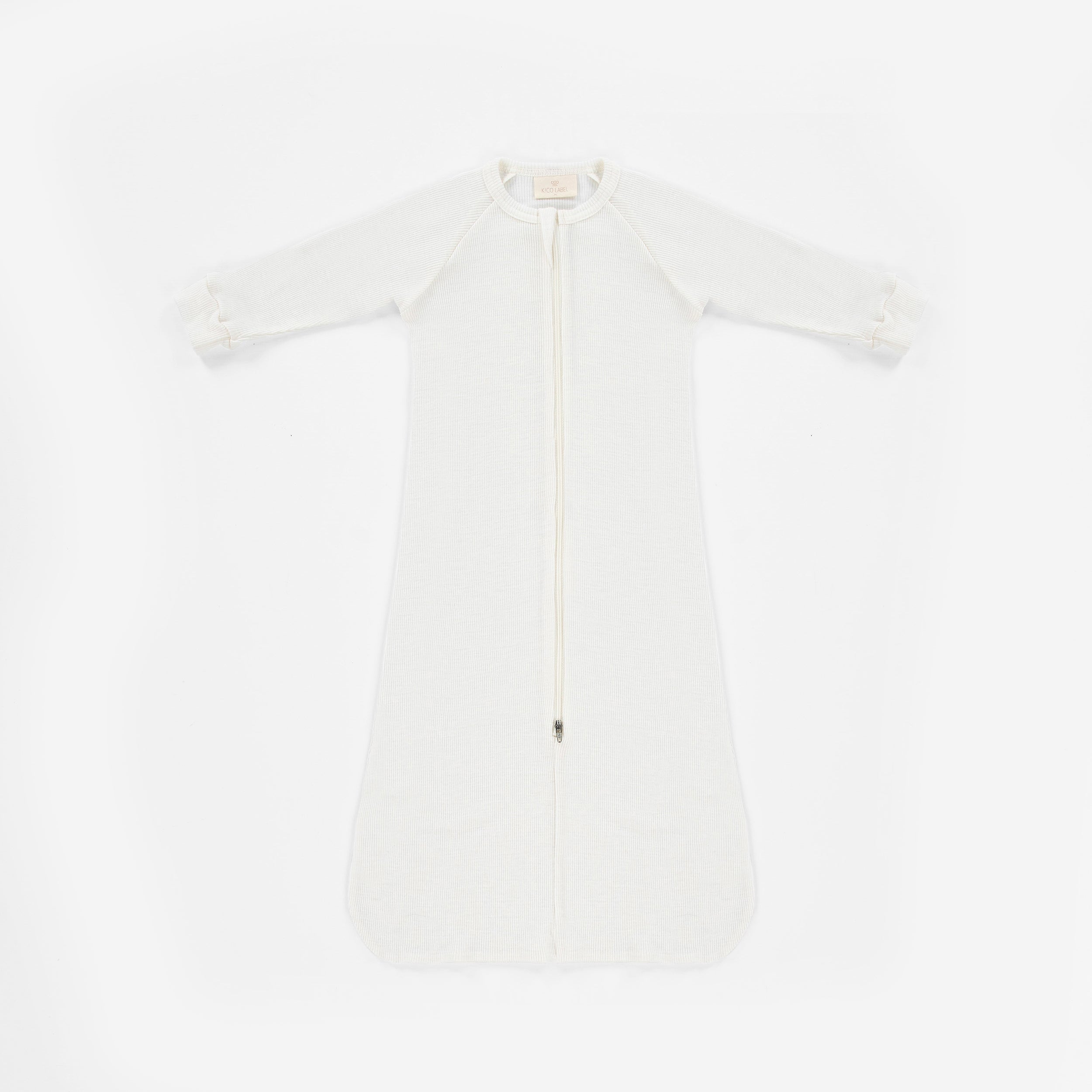 Witte wollen baby slaapzak met lange mouwen tegen een witte achtergrond