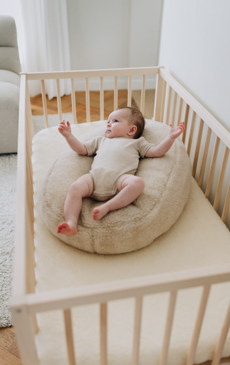 Baby ligt op voedingskussenhoes in de kleur beige