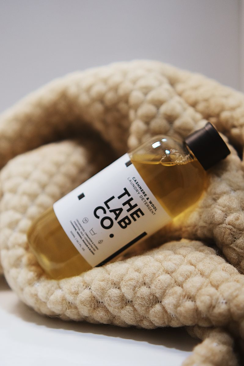 Natuurlijke wolwasmiddel van Kico Label op Kico Label deken, fles en sluitdop zichtbaar, klaar voor gebruik