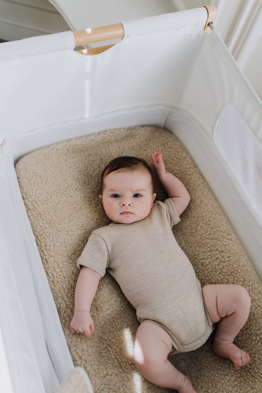 Baby ligt op merinowollen hoeslaken van Kico Label
