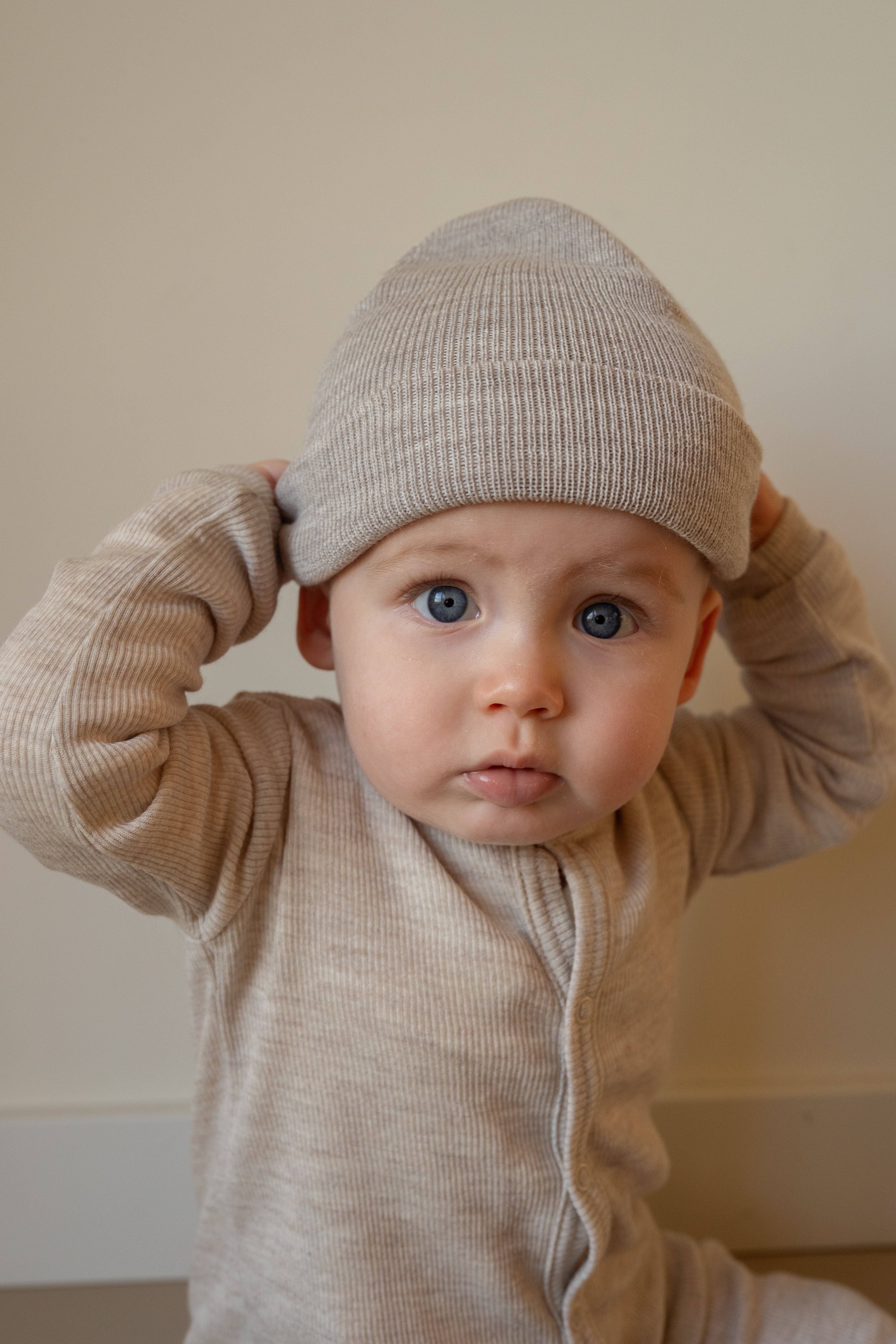 Kindje met de beige merinowollen muts – zachte gebreide wintermuts van merinowol