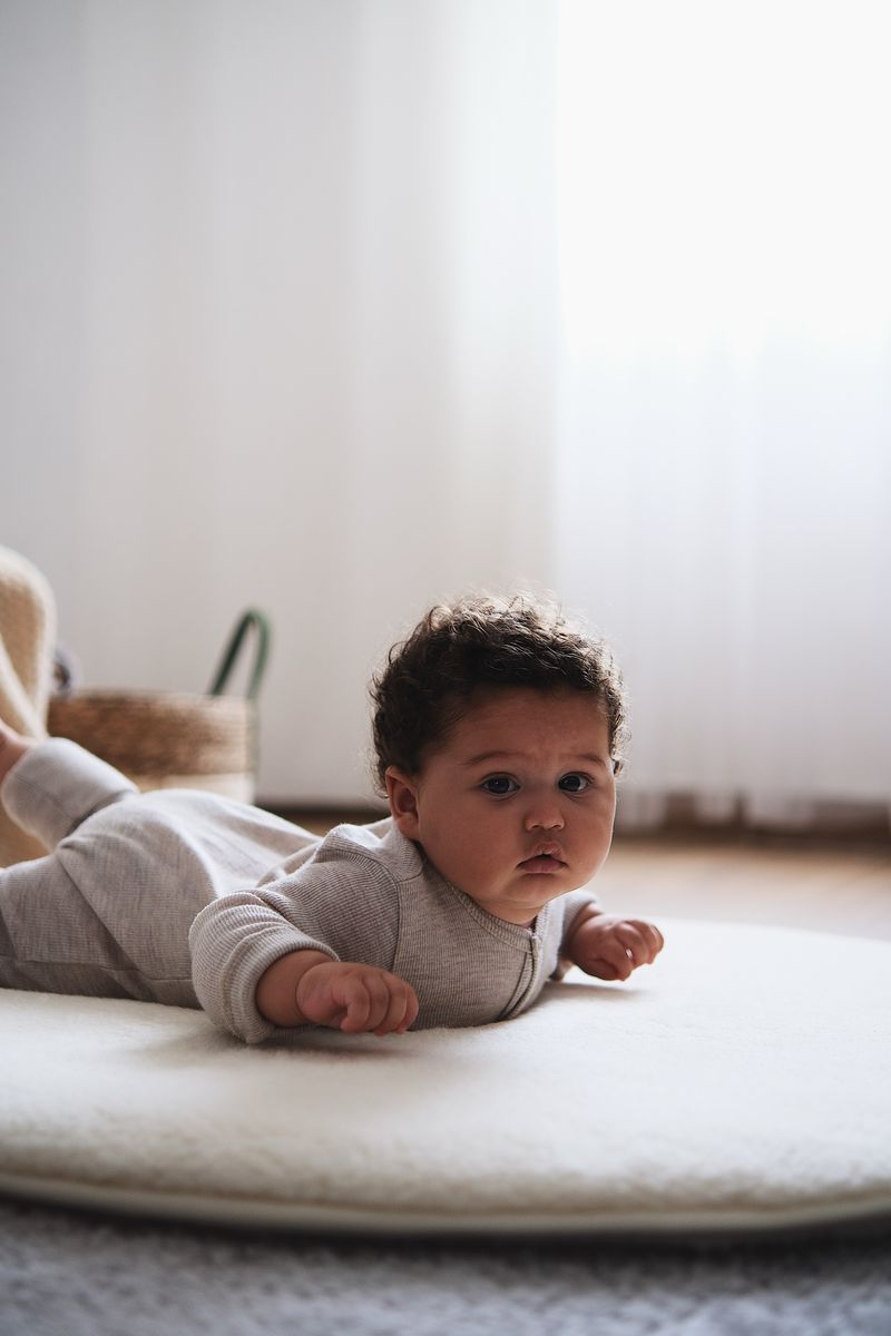 Baby ligt op rond boxkleed van naturel merinowol (90 cm)