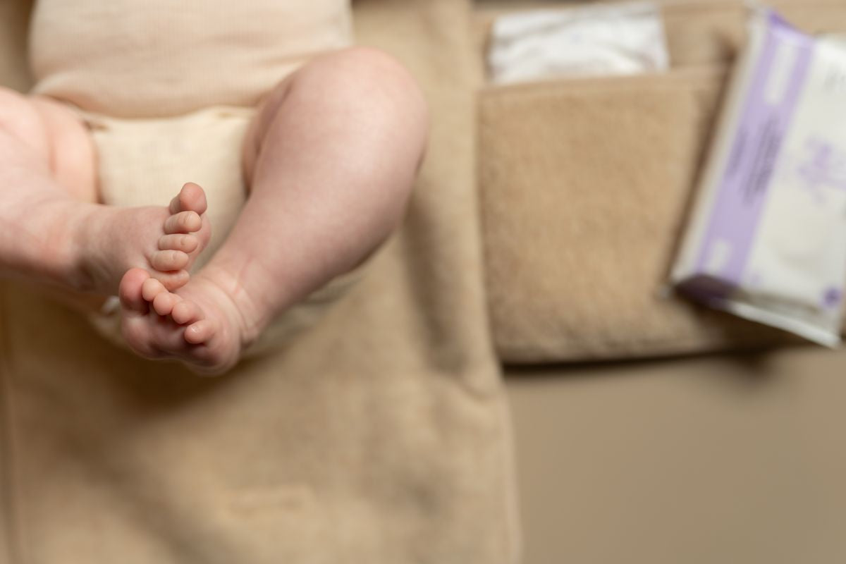 Kleintje ligt op Kico Label verschoonmat‑etui van merinowol, beige, comfortabele en natuurlijke ondergrond